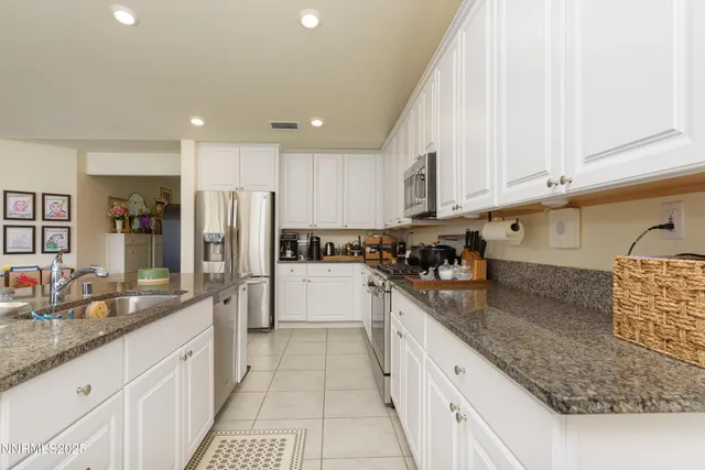 a large kitchen with stainless steel appliances granite countertop a sink stove and refrigerator
