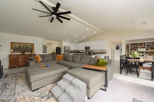 a living room with furniture kitchen view and a chandelier