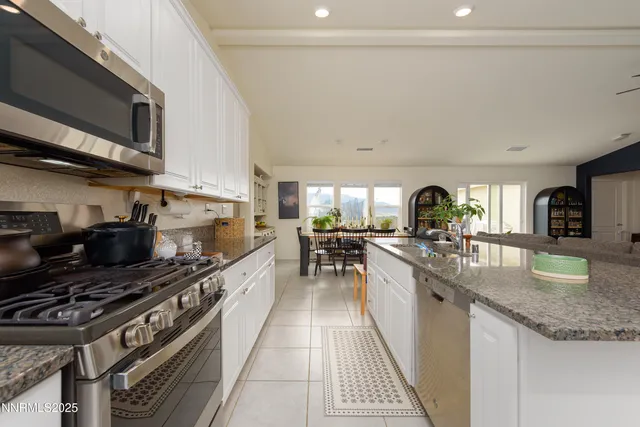 a kitchen with stainless steel appliances granite countertop a stove a sink and a microwave