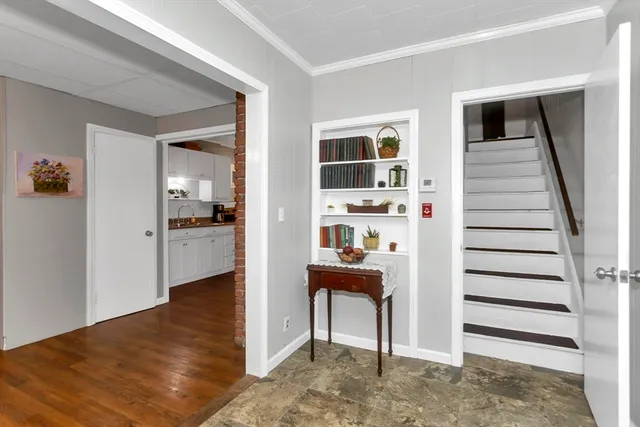 a view of a hallway with wooden floor and workspace