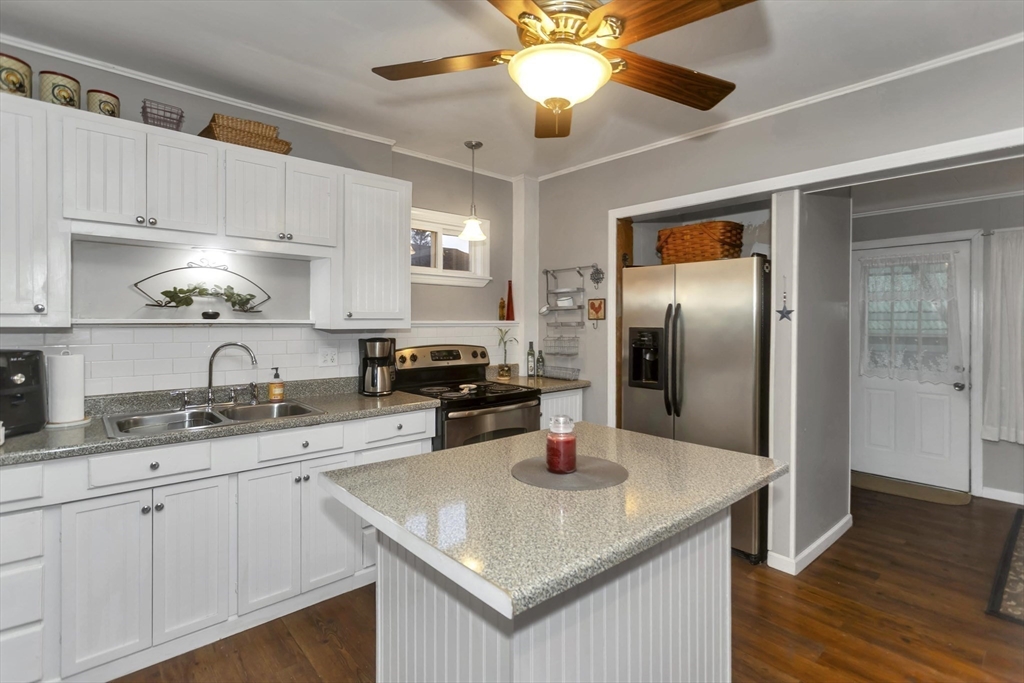 231 Wheatland Avenue Chicopee, MA 01020 - Photo 4 of 36 a kitchen with stainless steel appliances granite countertop a sink a refrigerator and cabinets