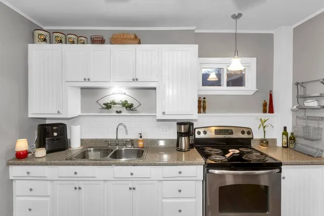 a kitchen with granite countertop a sink stainless steel appliances and cabinets