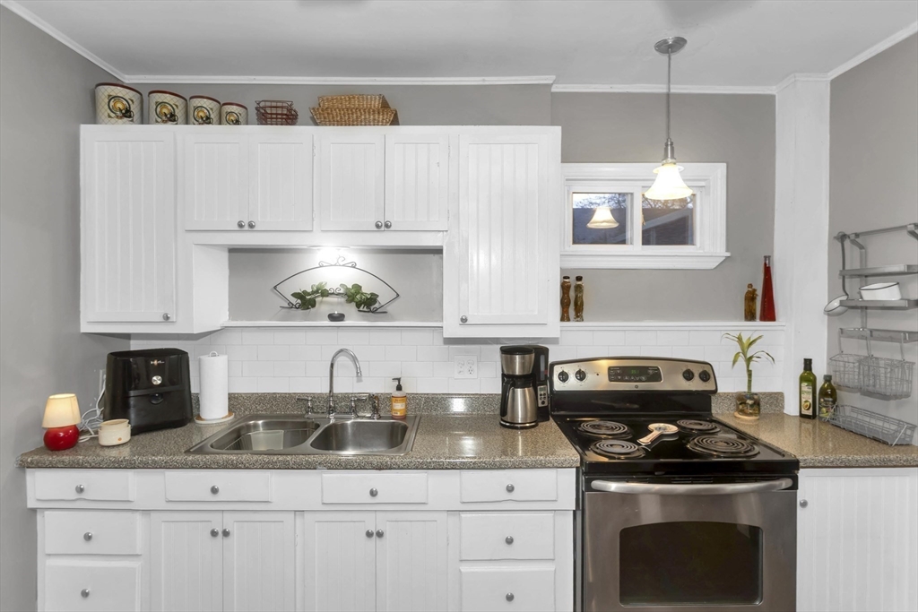 231 Wheatland Avenue Chicopee, MA 01020 - Photo 5 of 36 a kitchen with granite countertop a sink stainless steel appliances and cabinets