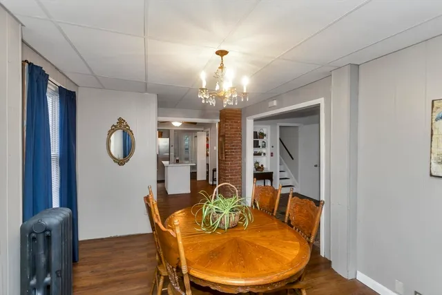 a dining room with furniture a chandelier and wooden floor