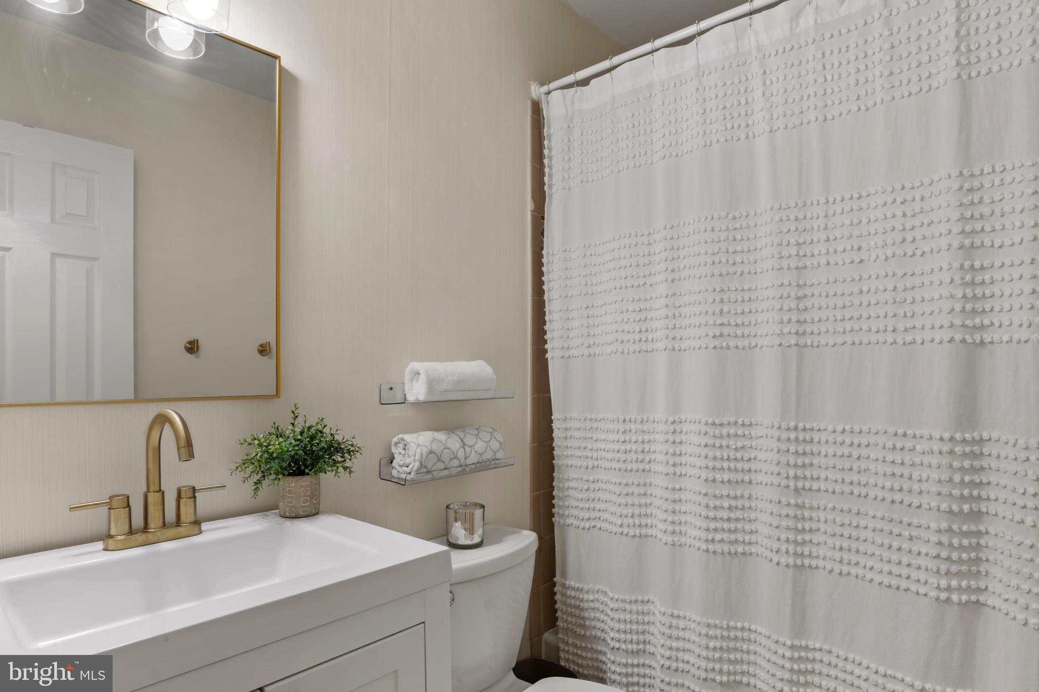9013 Brook Ford Road Burke, VA 22015 - Photo 11 of 28 a bathroom with a sink a toilet and shower curtain