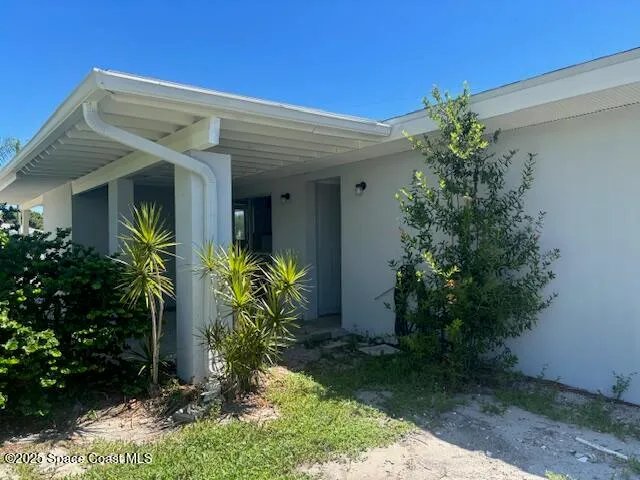 a view of a house with potted plants