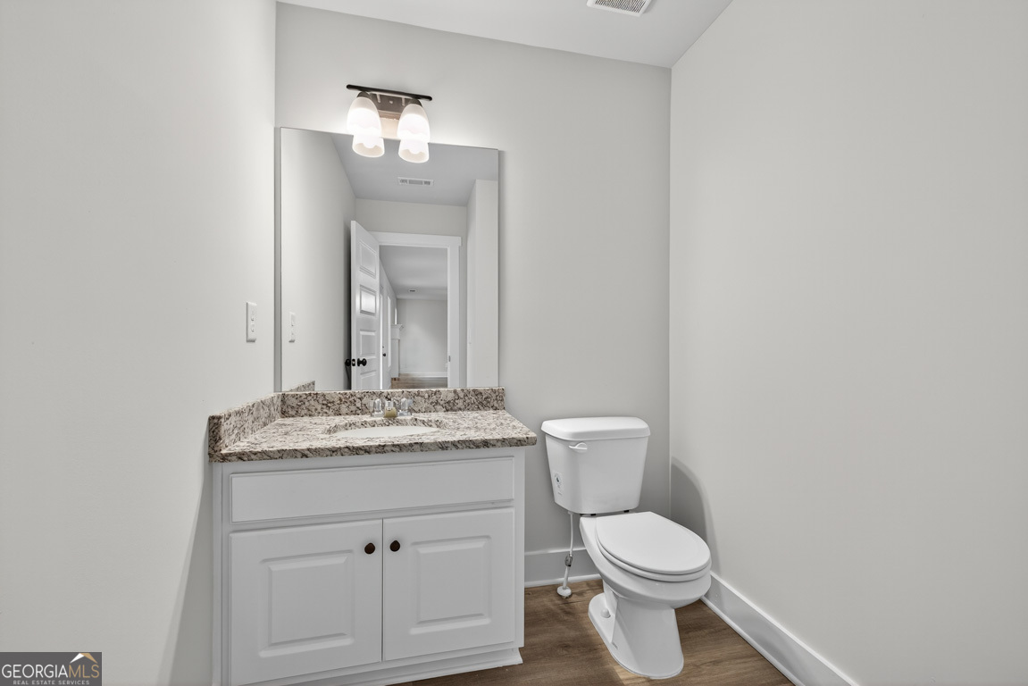77 Sugar Maple Way, Unit 44 Colbert, GA 30628 - Photo 14 of 30 a bathroom with a granite countertop toilet sink and mirror