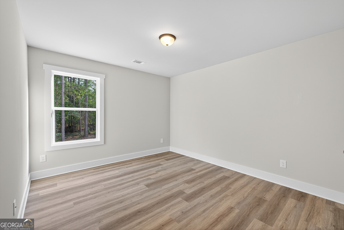 77 Sugar Maple Way, Unit 44 Colbert, GA 30628 - Photo 18 of 30 an empty room with wooden floor and windows