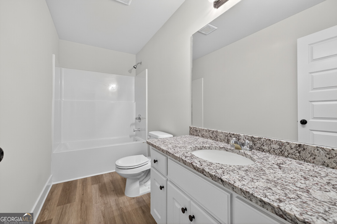 77 Sugar Maple Way, Unit 44 Colbert, GA 30628 - Photo 20 of 30 a bathroom with a granite countertop sink a toilet and shower