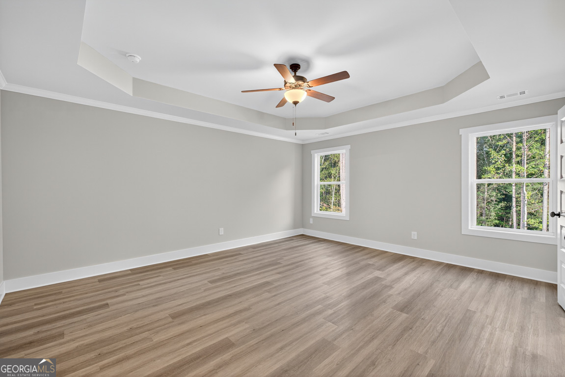 77 Sugar Maple Way, Unit 44 Colbert, GA 30628 - Photo 21 of 30 an empty room with wooden floor fan and windows