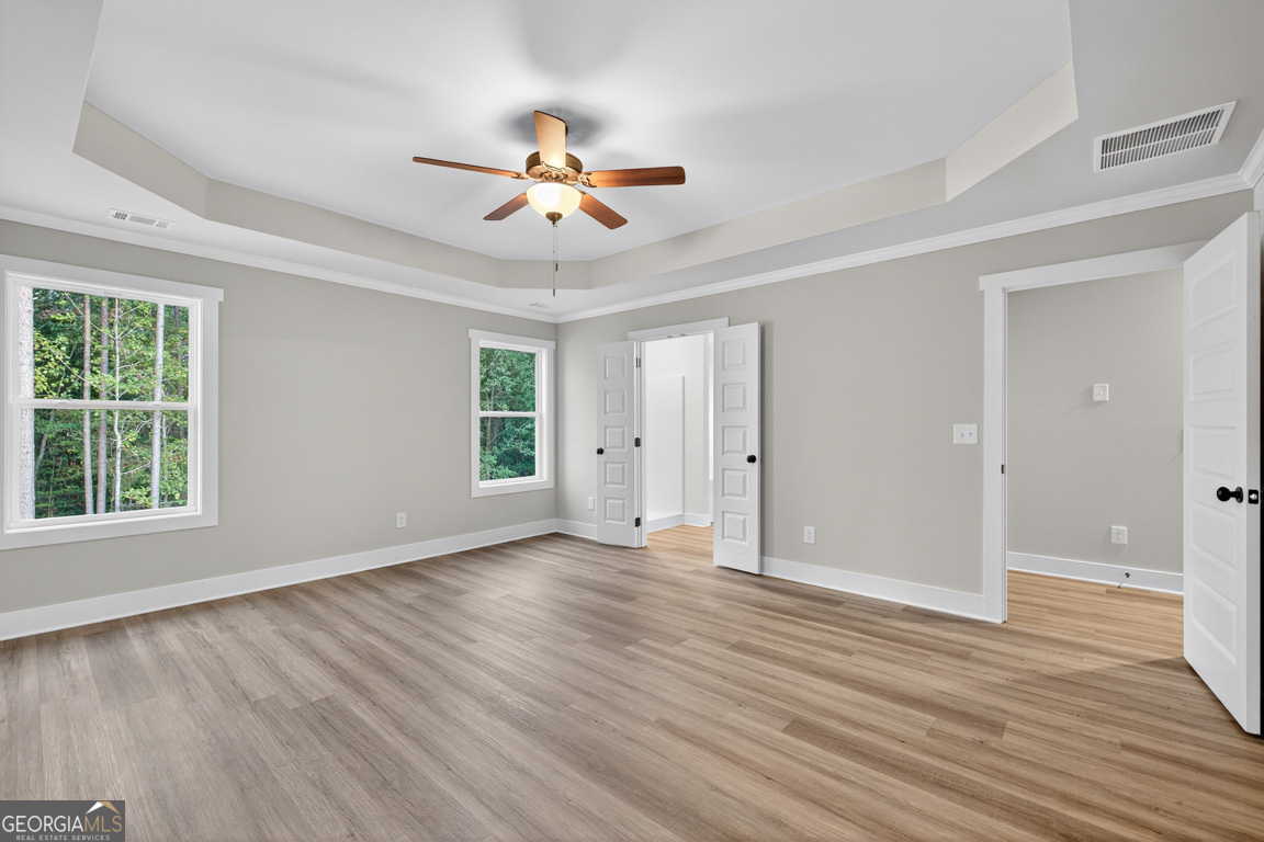 77 Sugar Maple Way, Unit 44 Colbert, GA 30628 - Photo 22 of 30 a view of an empty room with wooden floor and a window