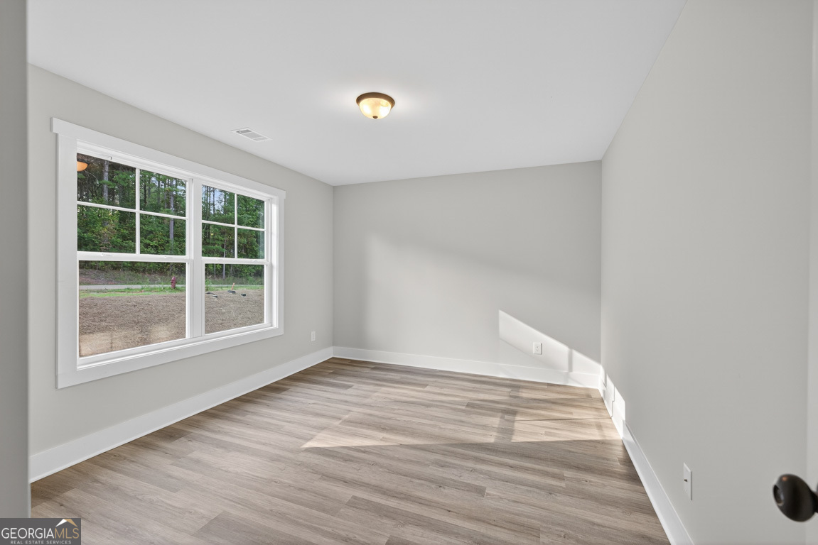 77 Sugar Maple Way, Unit 44 Colbert, GA 30628 - Photo 29 of 30 a view of an empty room with wooden floor and a window