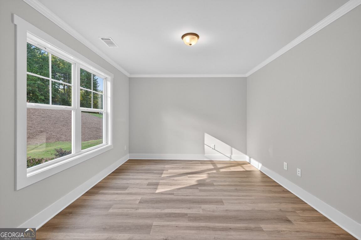 77 Sugar Maple Way, Unit 44 Colbert, GA 30628 - Photo 4 of 30 a view of an empty room with wooden floor and a window