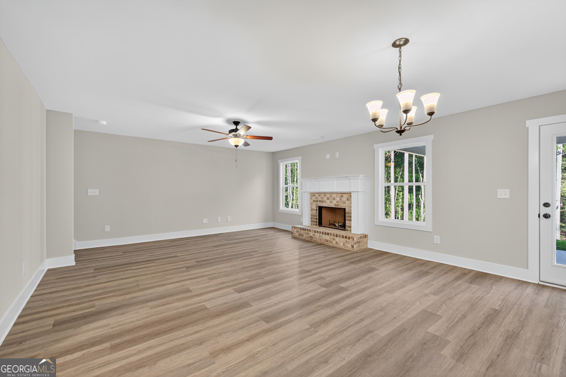 77 Sugar Maple Way, Unit 44 Colbert, GA 30628 - Photo 6 of 30 a view of an empty room with a chandelier fan and kitchen view