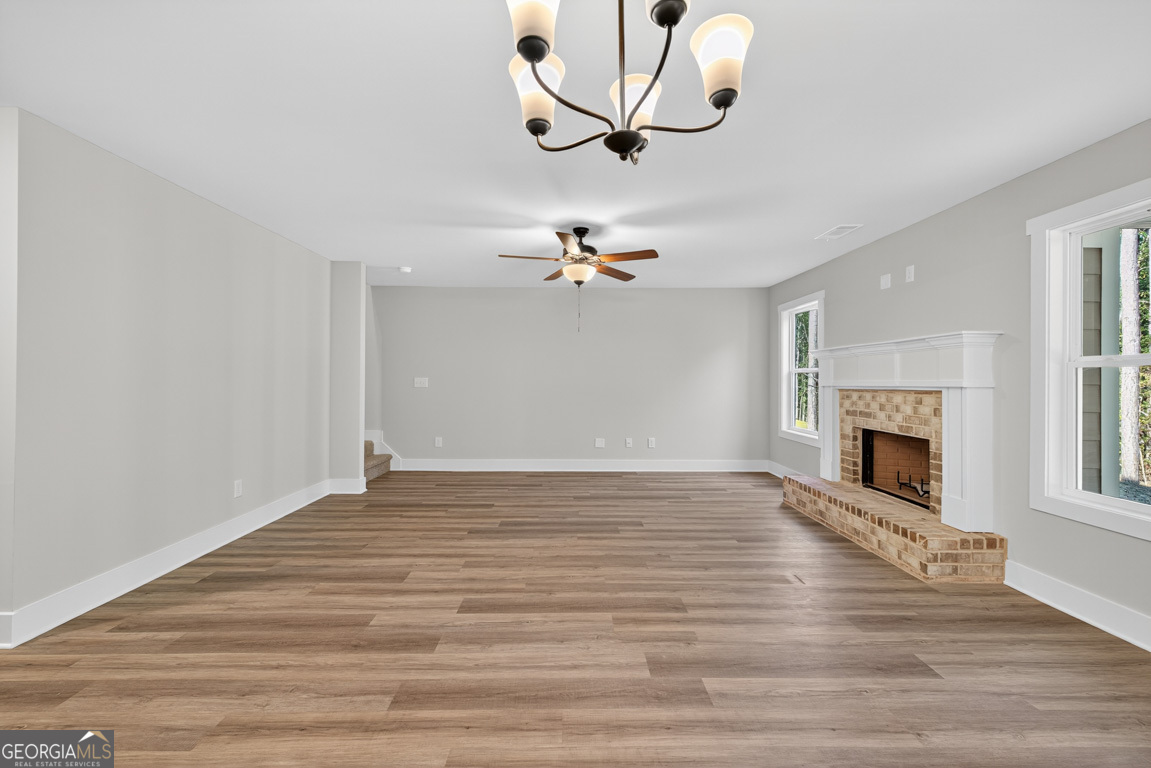 77 Sugar Maple Way, Unit 44 Colbert, GA 30628 - Photo 7 of 30 a view of a livingroom with wooden floor a ceiling fan and a fireplace