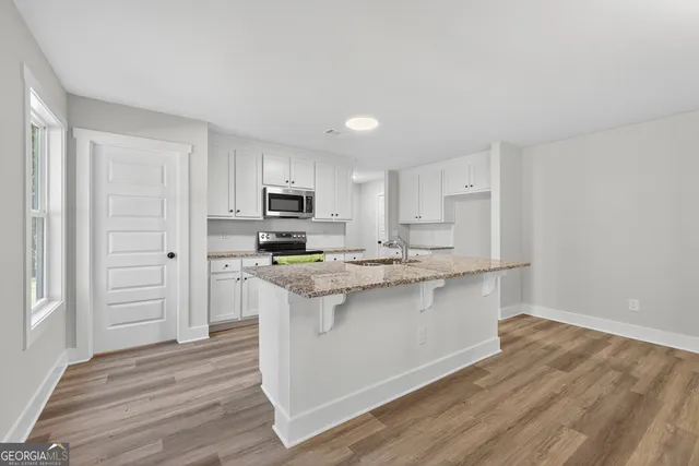 a kitchen with stainless steel appliances a sink stove and refrigerator