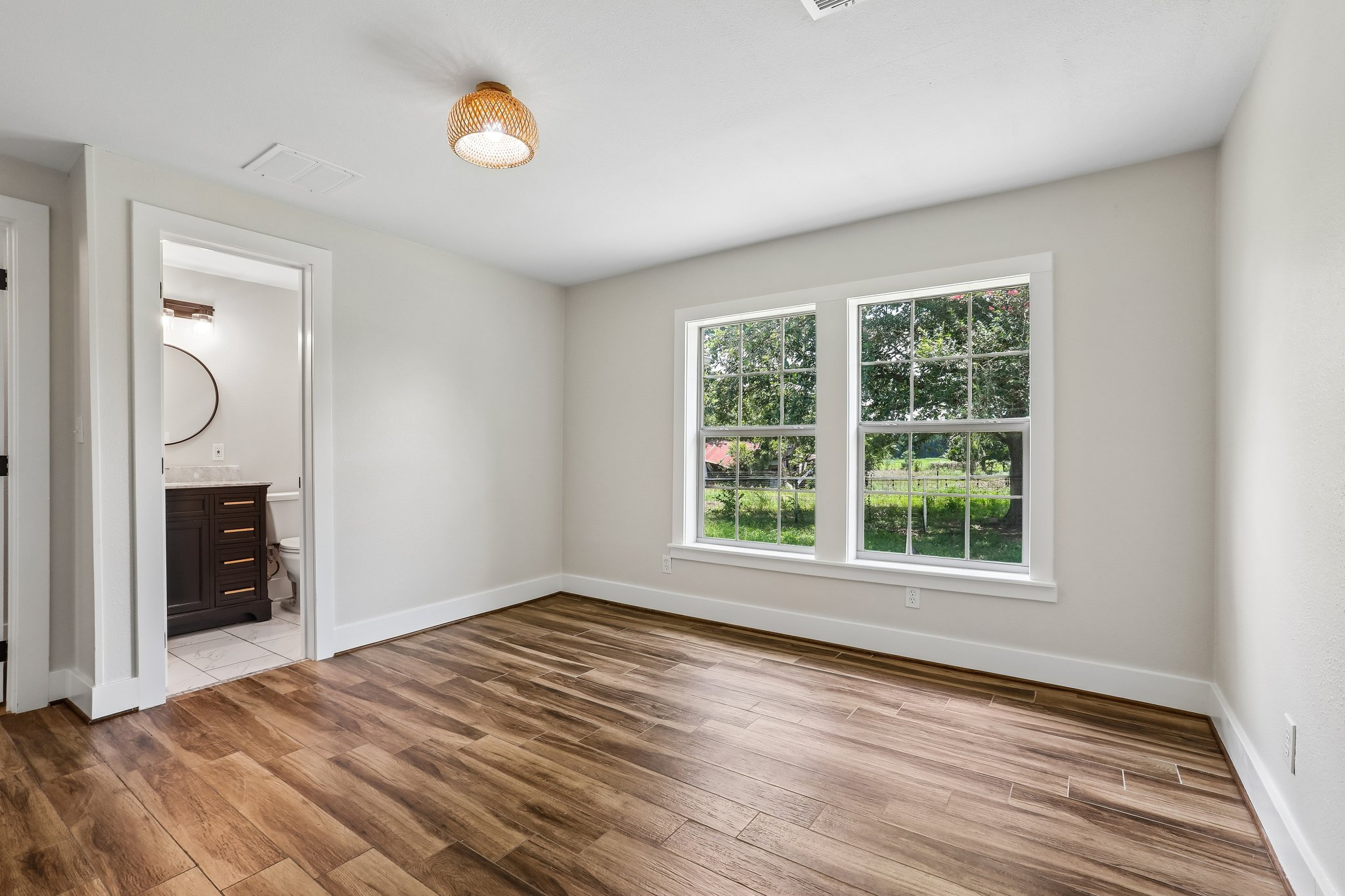 2089 Farm To Market Road 1704 Elgin, TX 78621 - Photo 18 of 31 Two large windows provide ample natural light, highlighting the rich wood flooring throughout this versatile space.