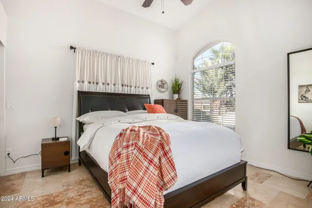 a bed sitting in a bedroom next to a window
