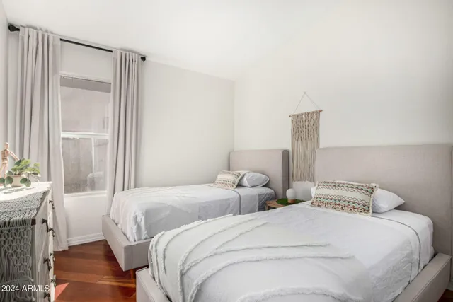 a bedroom with two beds and a large mirror