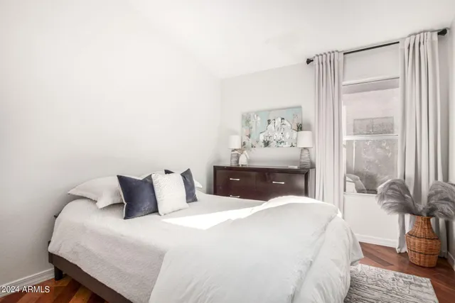 a bedroom with a bed and a painting on the wall