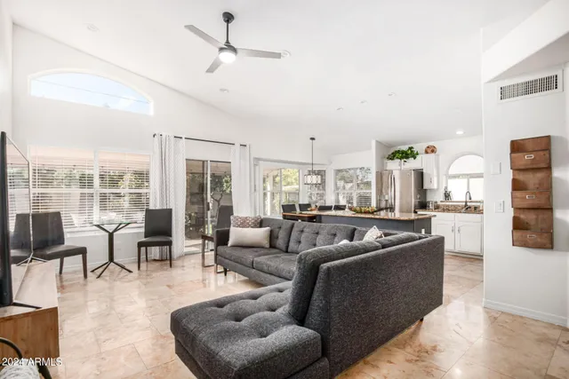 a living room with furniture wooden floor and a large window