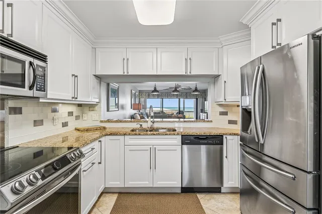 a kitchen with stainless steel appliances granite countertop a refrigerator stove and sink