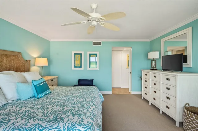 a bedroom with a large bed and a flat tv screen on dresser