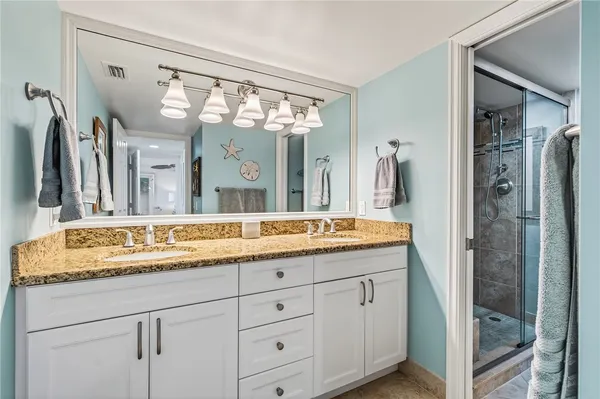 a bathroom with a granite countertop sink and a mirror