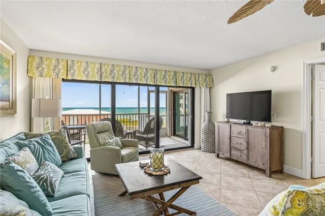 a living room with furniture a flat screen tv and a large window