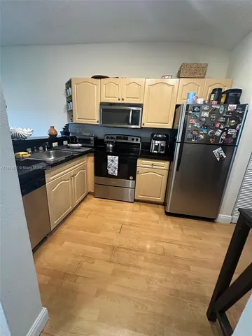 a kitchen with granite countertop a refrigerator and a stove top oven