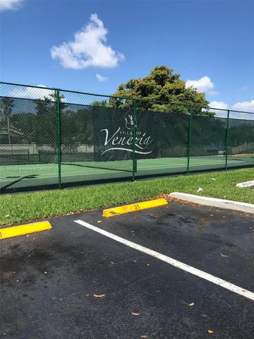 a view of a house with a yard and large trees