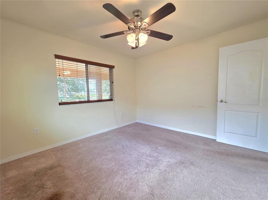 4284 High Ridge Avenue Spring Hill, FL 34609 - Photo 34 of 40 an empty room with a chandelier fan and windows