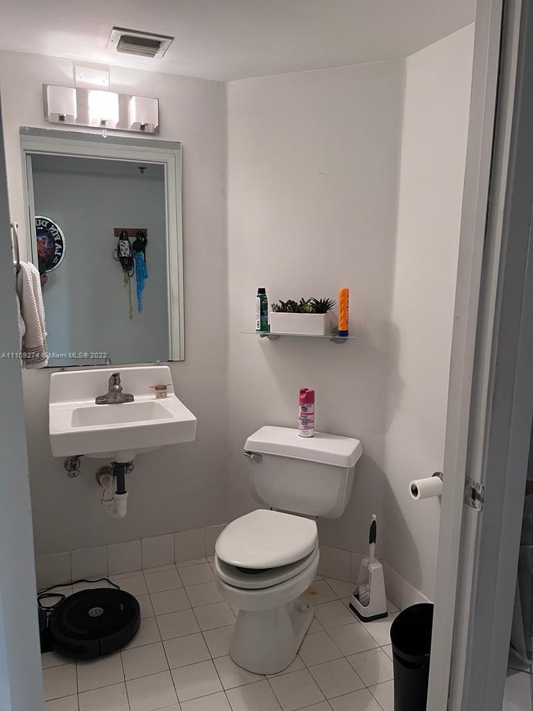 2351 Douglas Road, Unit 908 Miami, FL 33145 - Photo 17 of 17 a bathroom with a toilet sink and mirror