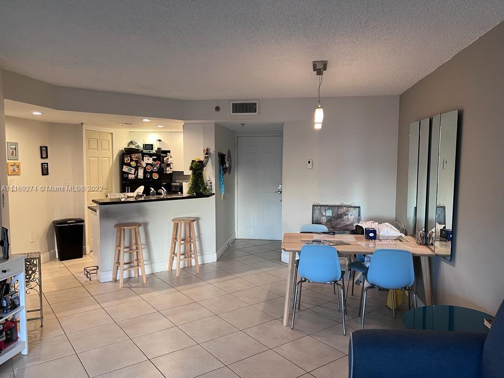 2351 Douglas Road, Unit 908 Miami, FL 33145 - Photo 4 of 17 a view of a dining room with furniture and chandelier