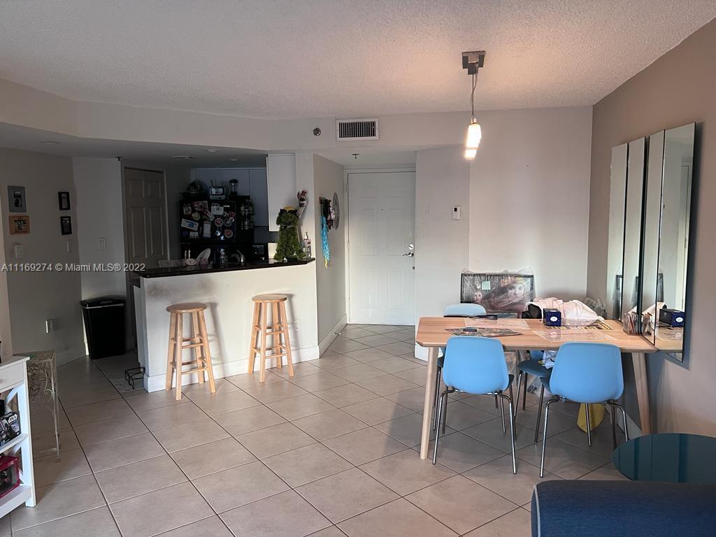 2351 Douglas Road, Unit 908 Miami, FL 33145 - Photo 5 of 17 a view of a dining room with furniture and chandelier