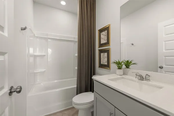 a bathroom with a granite countertop sink a toilet and shower