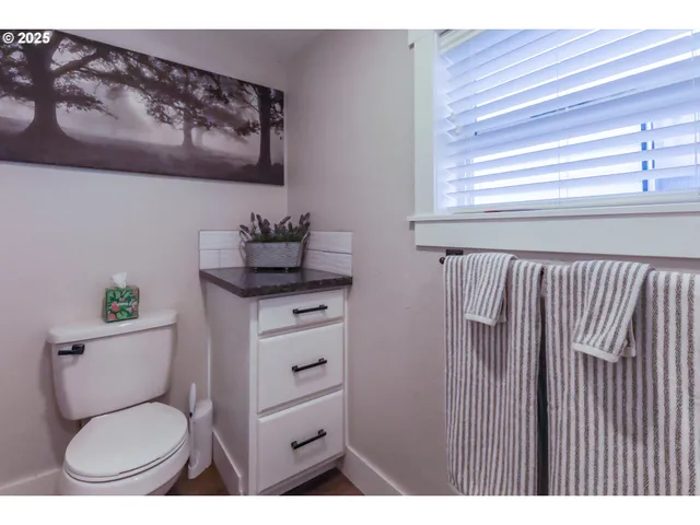 a bathroom with a toilet a sink and a window