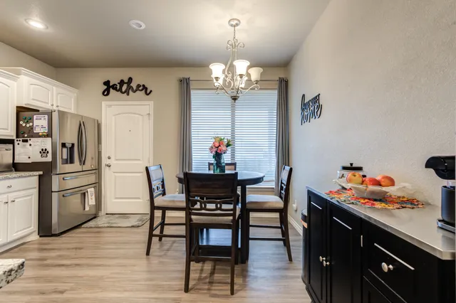 a view of a dining room with furniture a chandelier and wooden floor