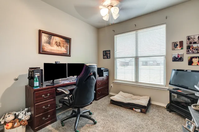 a view of a workspace with furniture and a window
