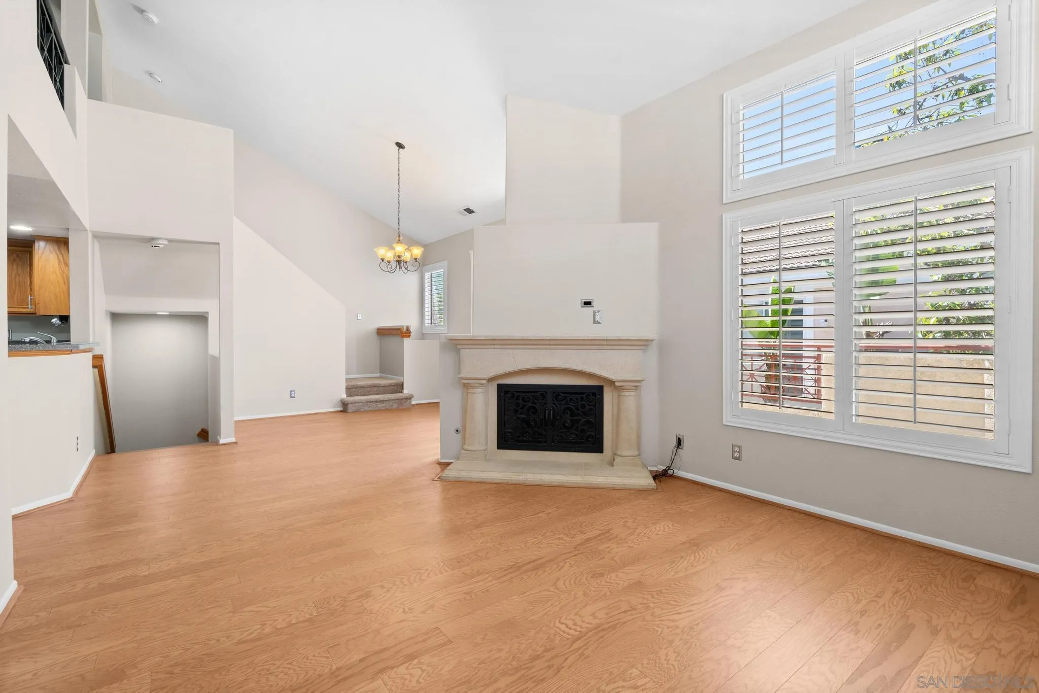 9338 Babauta Road, Unit 78 San Diego, CA 92129 - Photo 3 of 26 a view of a livingroom with a fireplace a ceiling fan and windows