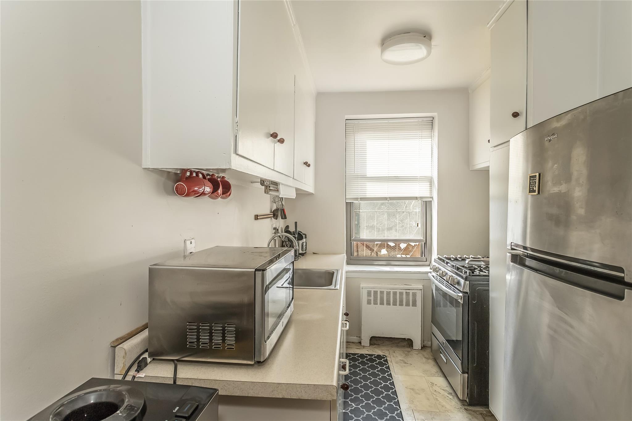 32-22 92nd Street, Unit 603 Queens, NY 11369 - Photo 12 of 25 a room with a chair and a stove top oven