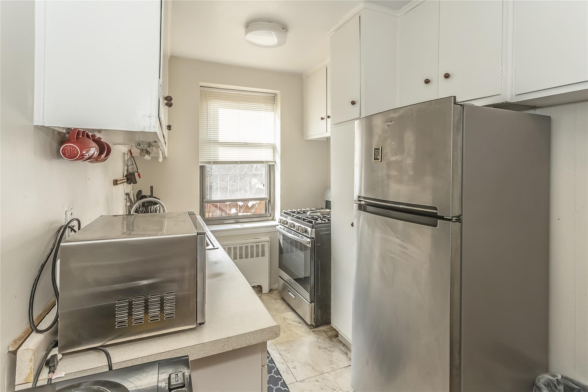 32-22 92nd Street, Unit 603 Queens, NY 11369 - Photo 14 of 25 a kitchen with a refrigerator and a sink