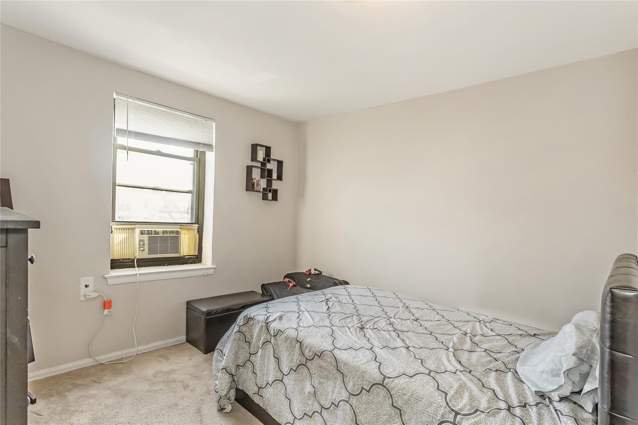 32-22 92nd Street, Unit 603 Queens, NY 11369 - Photo 17 of 25 a bedroom with a bed and a window