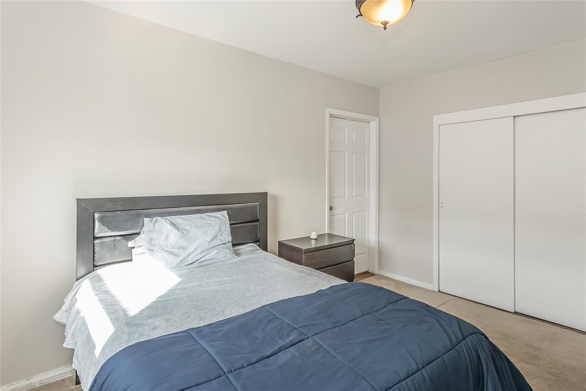 32-22 92nd Street, Unit 603 Queens, NY 11369 - Photo 20 of 25 a bedroom with a bed and a potted plant