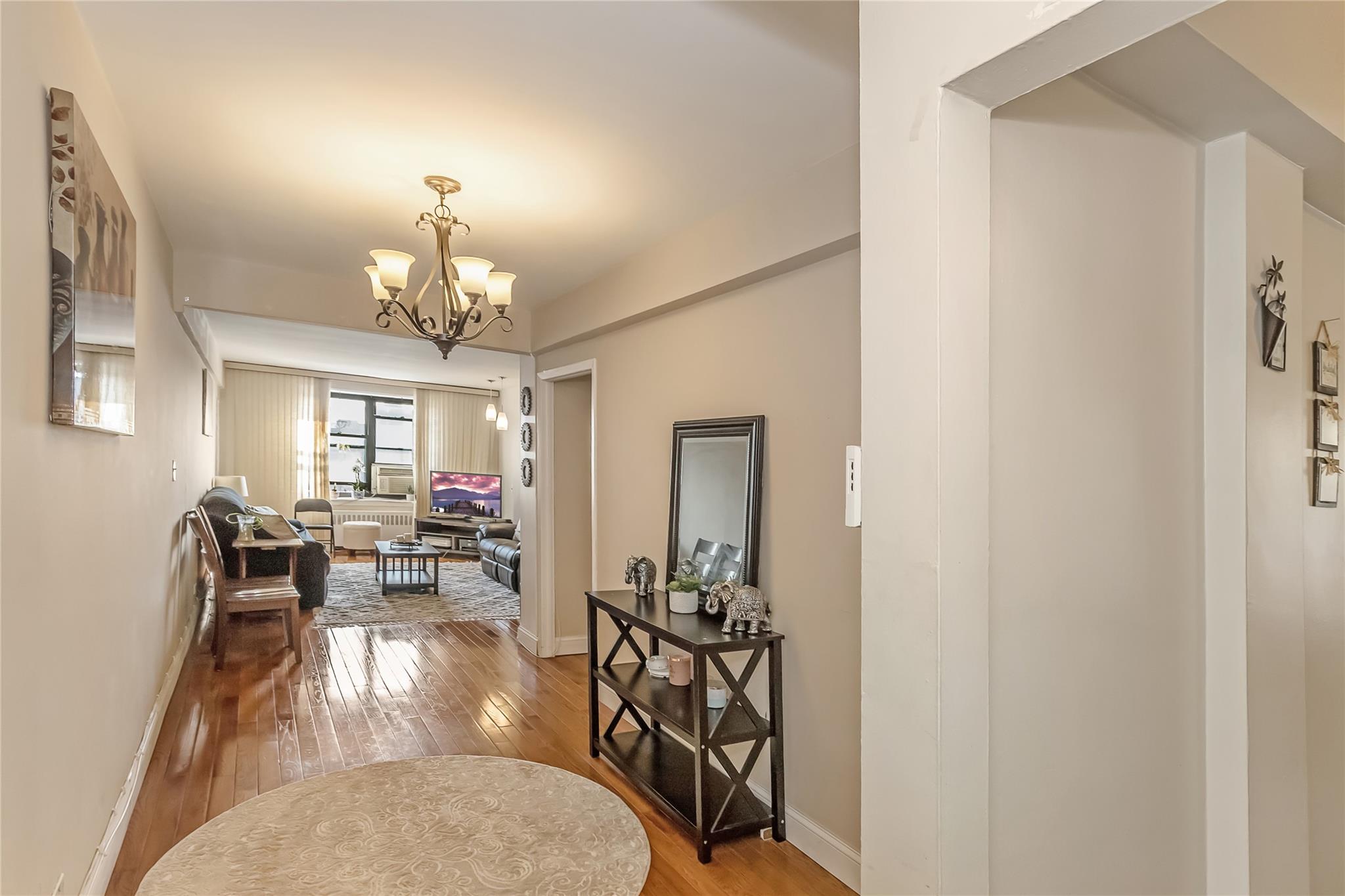 32-22 92nd Street, Unit 603 Queens, NY 11369 - Photo 5 of 25 a view of a livingroom with furniture and chandelier