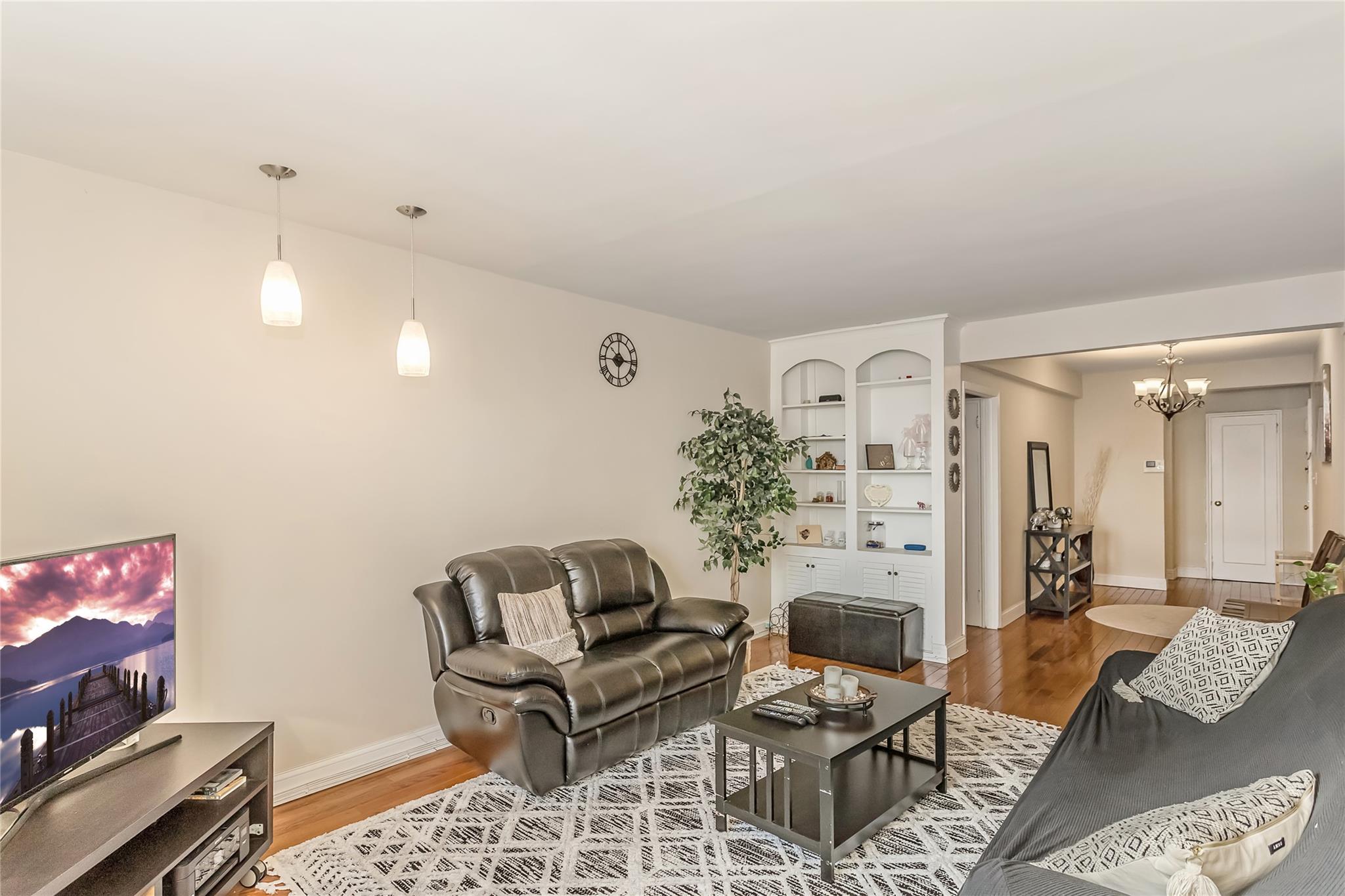 32-22 92nd Street, Unit 603 Queens, NY 11369 - Photo 6 of 25 a living room with furniture and wooden floor