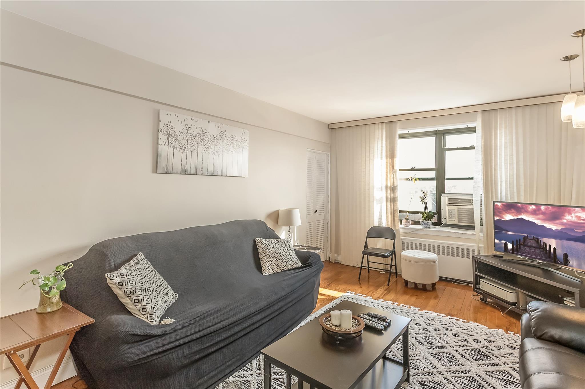 32-22 92nd Street, Unit 603 Queens, NY 11369 - Photo 8 of 25 a living room with furniture and a window