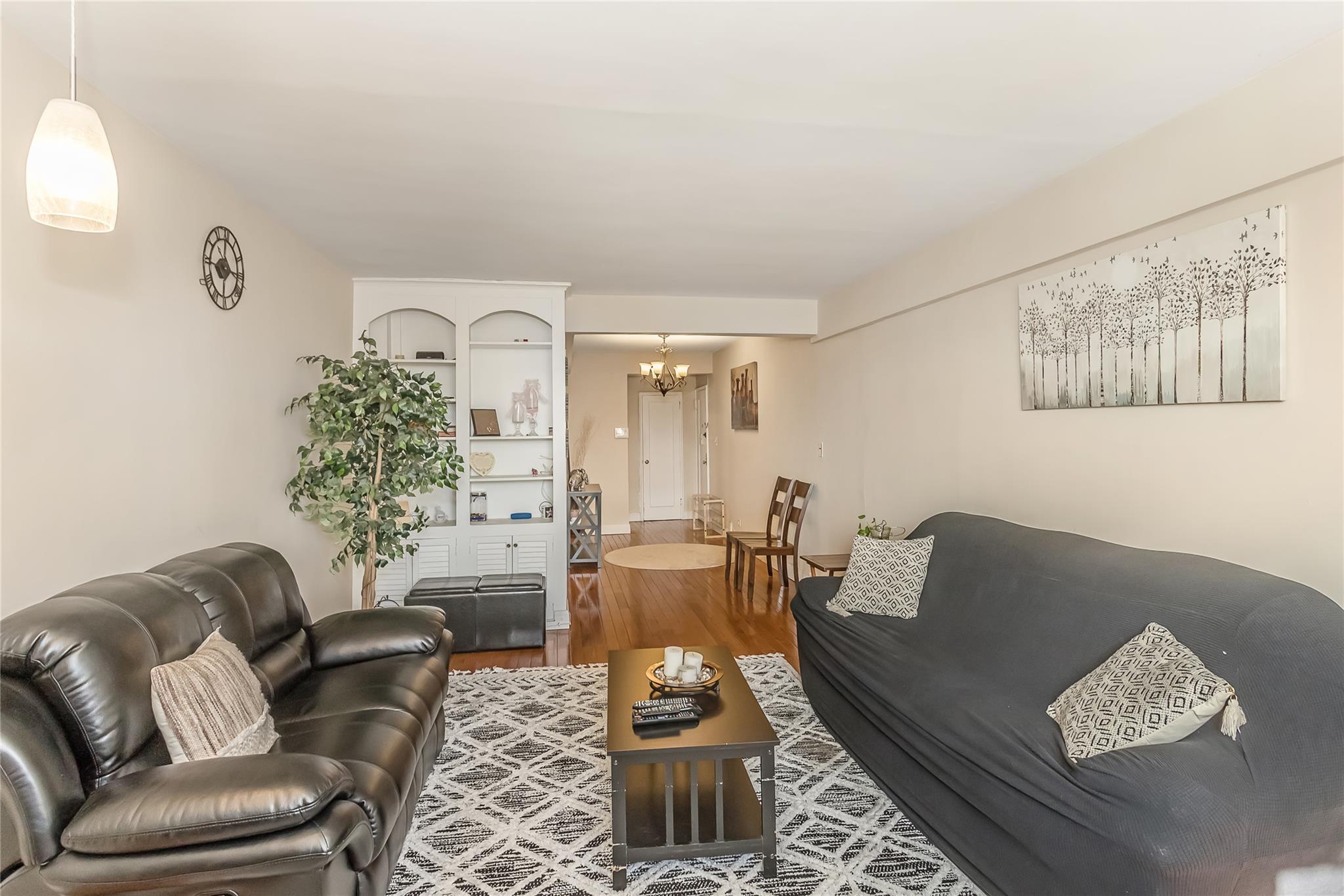 32-22 92nd Street, Unit 603 Queens, NY 11369 - Photo 9 of 25 a living room with furniture and wooden floor