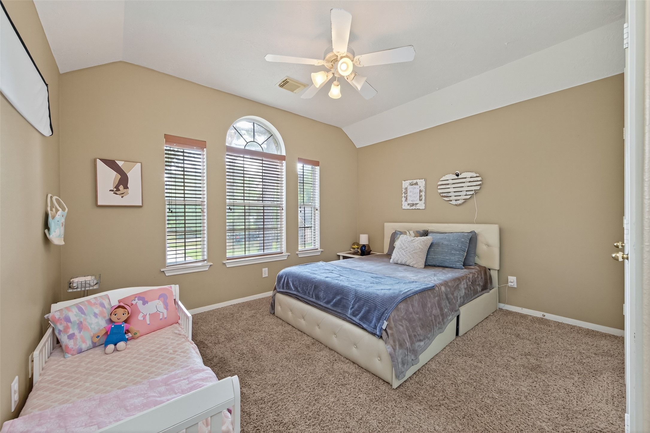 59 Genesee Ridge Drive Conroe, TX 77385 - Photo 24 of 44 a bedroom with a bed and a chandelier