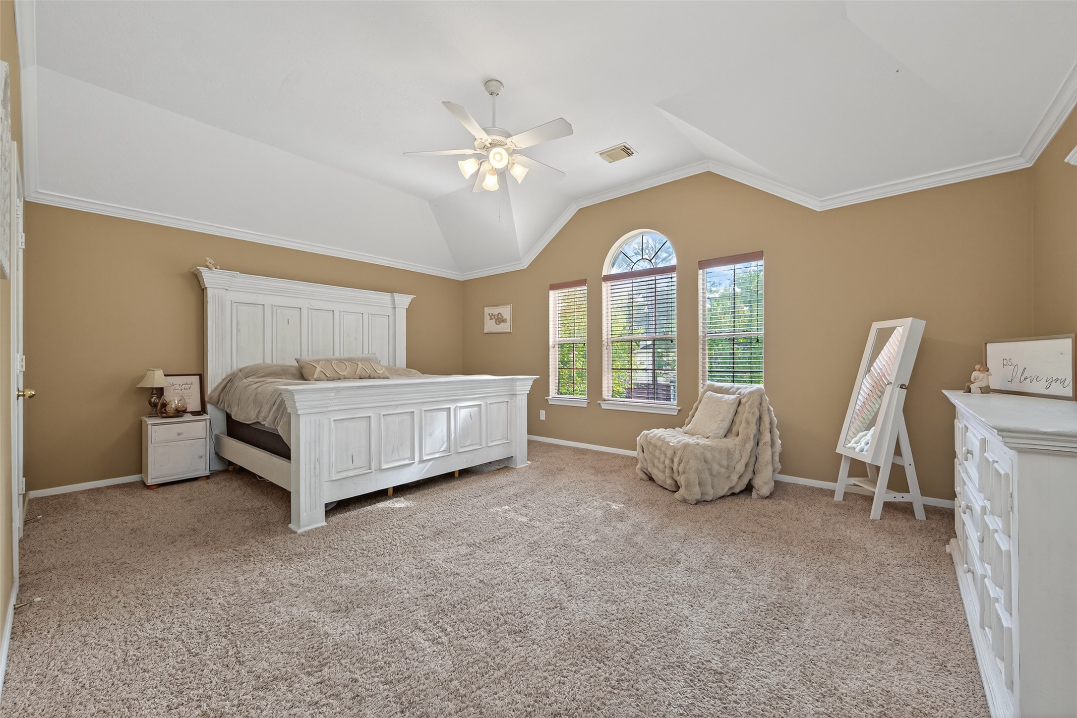 59 Genesee Ridge Drive Conroe, TX 77385 - Photo 32 of 44 a spacious bedroom with a bed and a chandelier